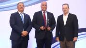 En el centro, el presidente saliente BASC Dominicana, Armando Rivas, recibe un reconocimiento del presidente entrante, Horacio Loma, y del vicepresidente ejecutivo de la Cámara Americana de Comercio, William Malamud. Se resaltó que las certificaciones de comercio seguro favorecen a empresas dominicanas.